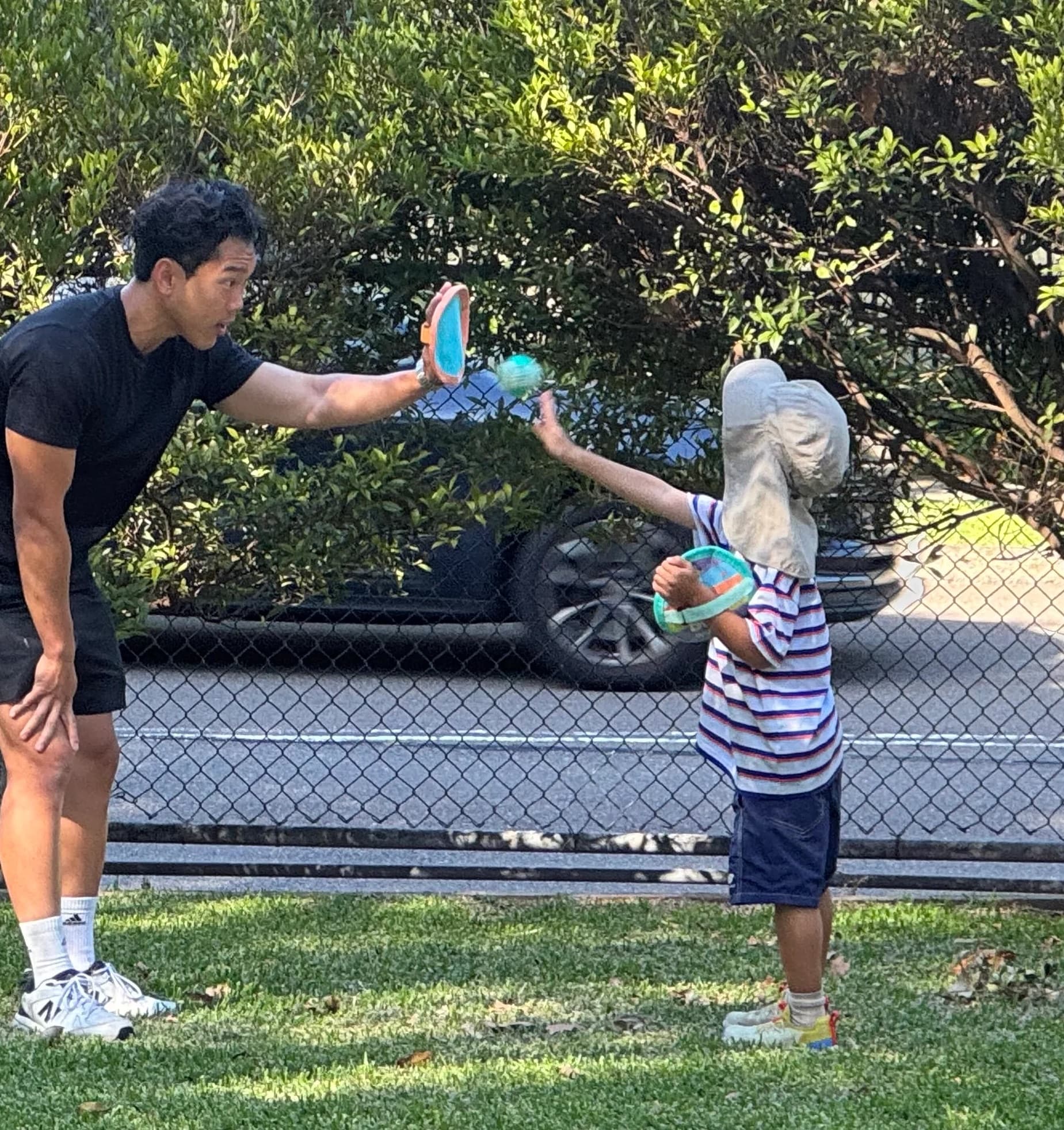A Drift Health practitioner playing catch with a young participant in the park