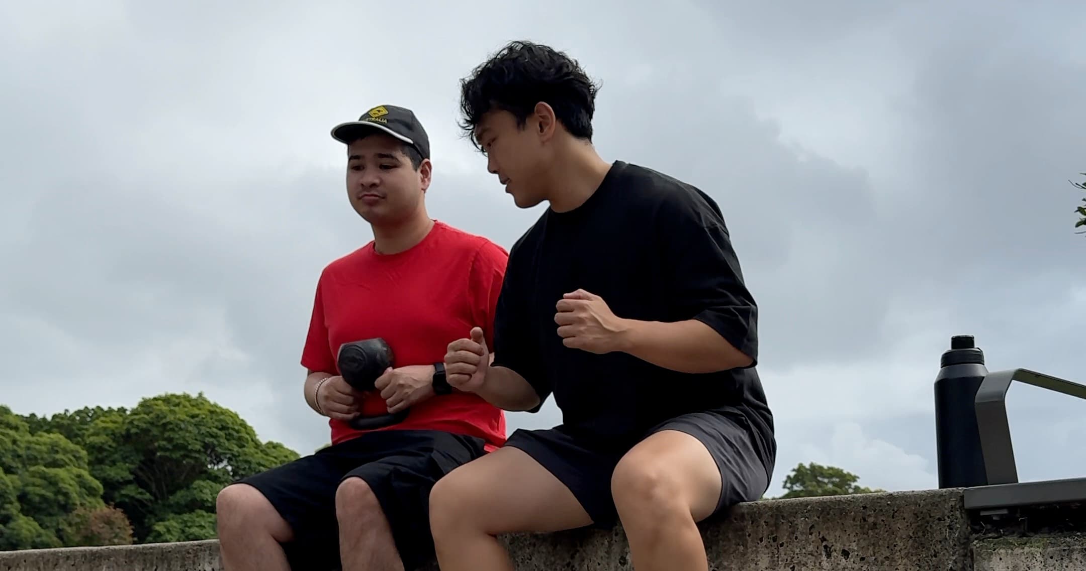 Drift Health exercise physiologist guiding an NDIS participant through a seated exercise outdoors