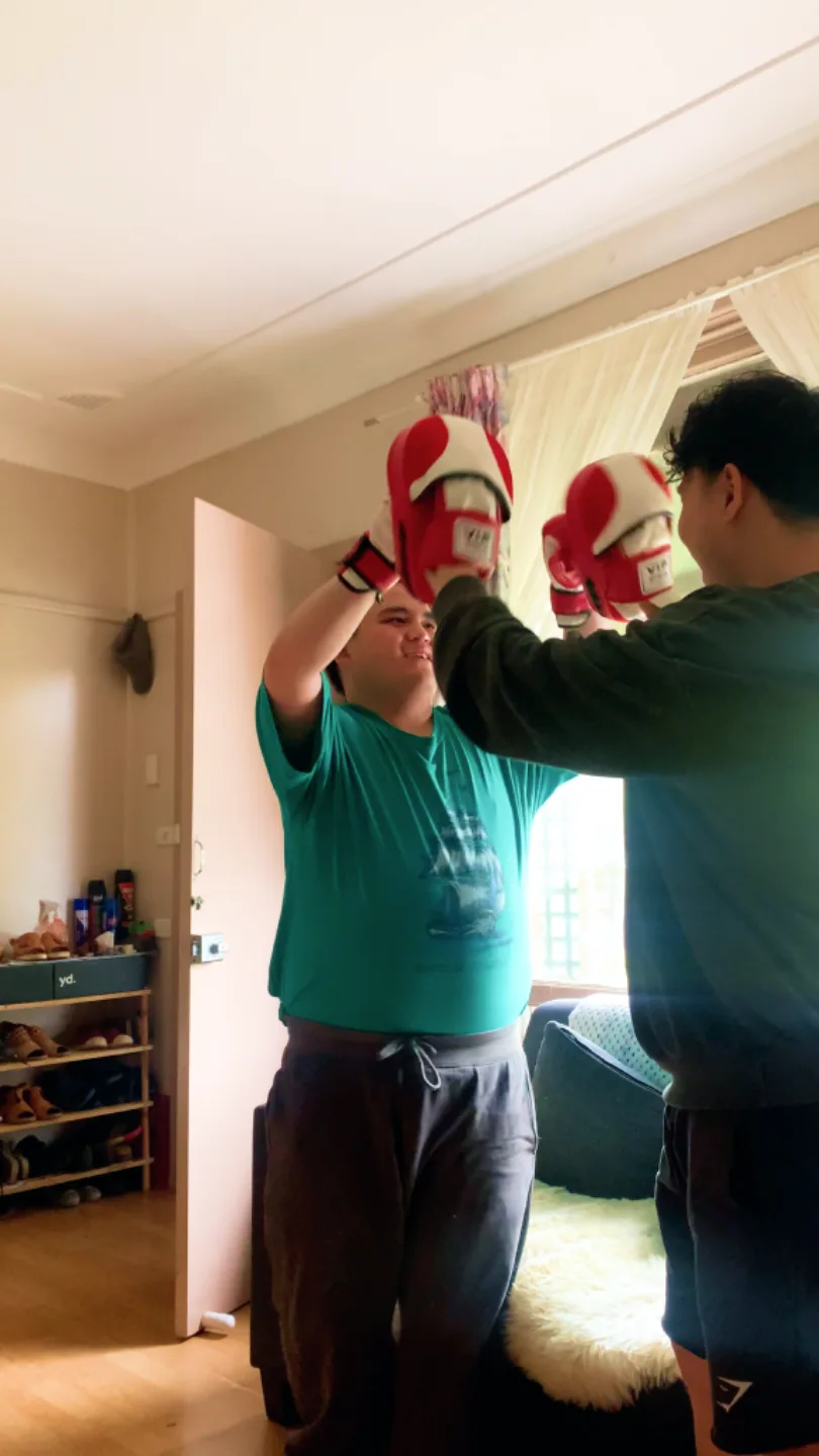 An adult participant practising boxing with a Drift Health therapist at home