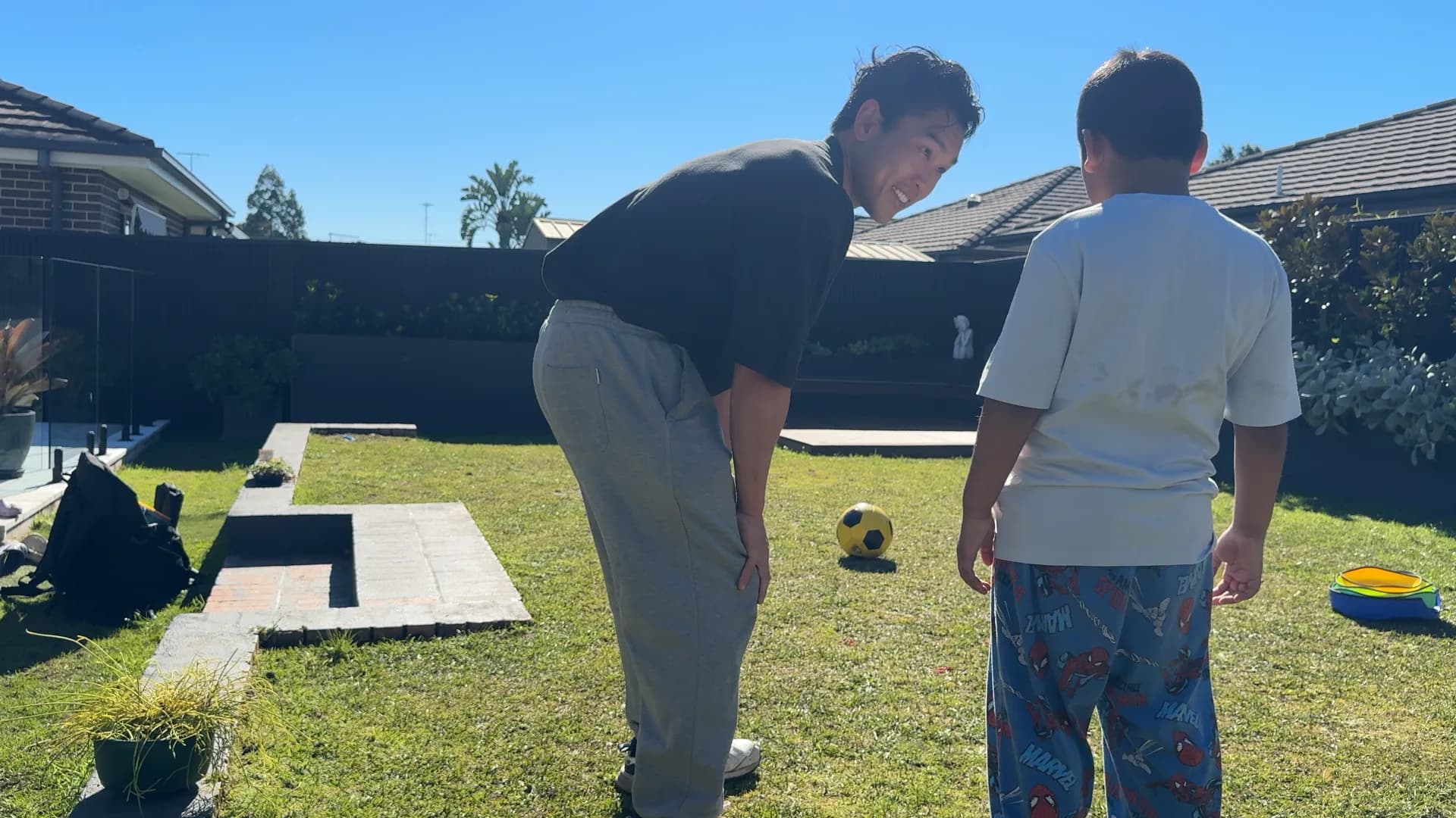 Victor looking at a child during a one-on-one backyard exercise session