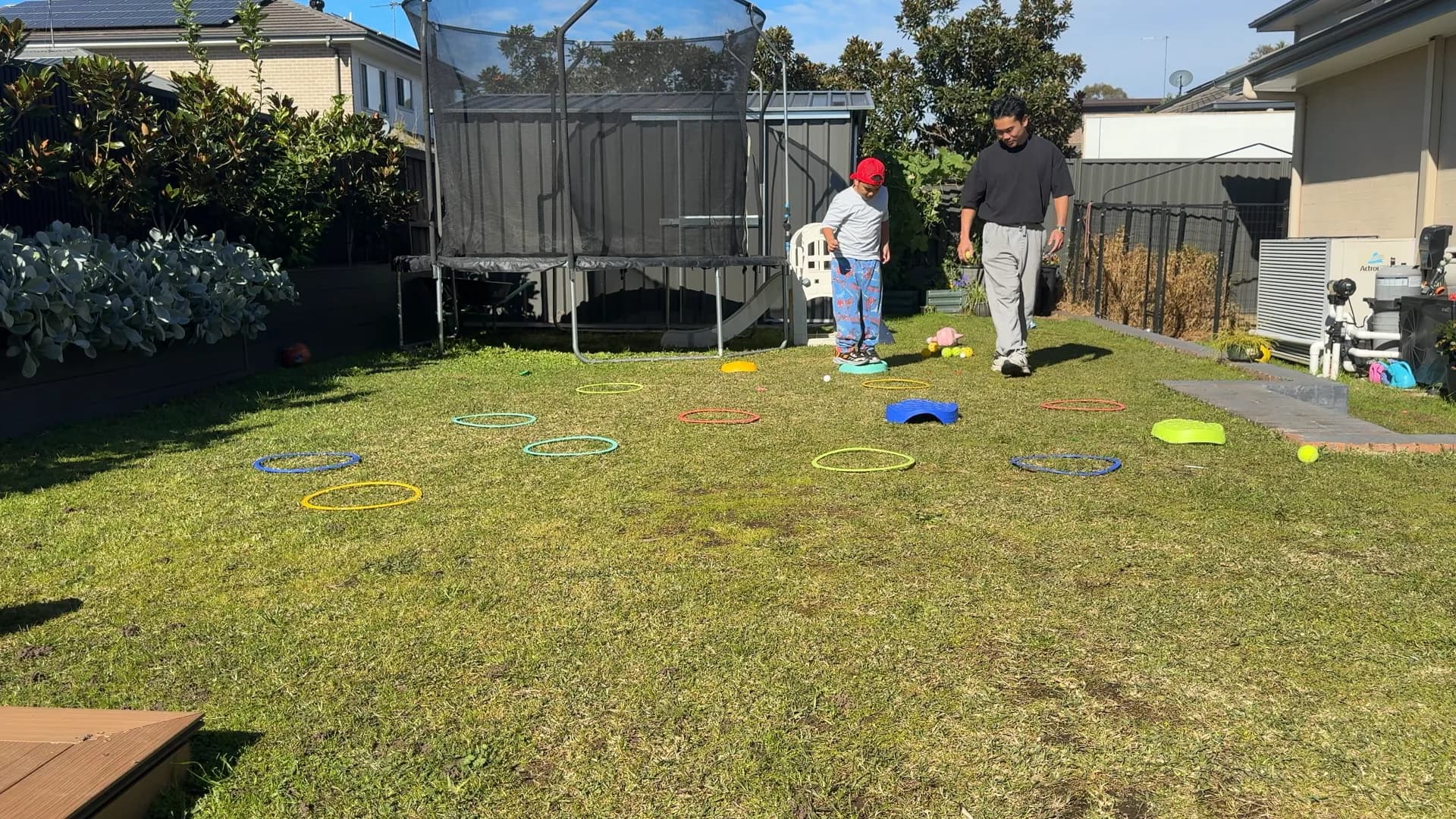 A child playing a jumping game with a therapist