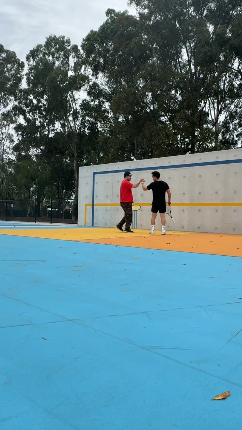 A participant and Drift Health therapist celebrating an outdoor tennis session