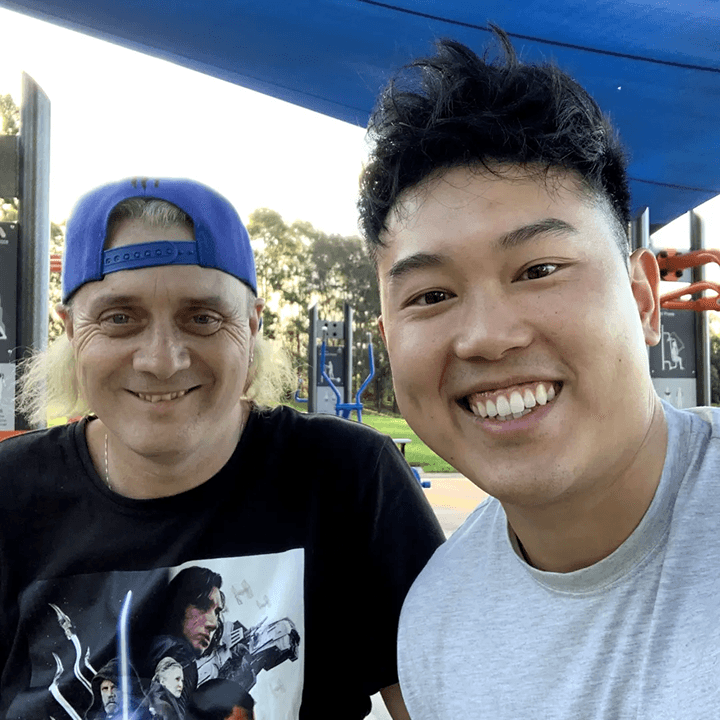 A smiling man in a blue cap and a Drift Health exercise physiologist taking a selfie at a local park