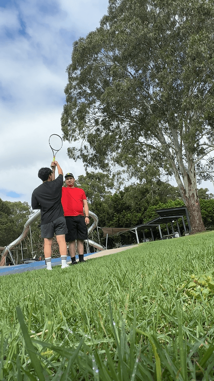 A Drift Health exercise physiologist playing tennis with a participant at a local park