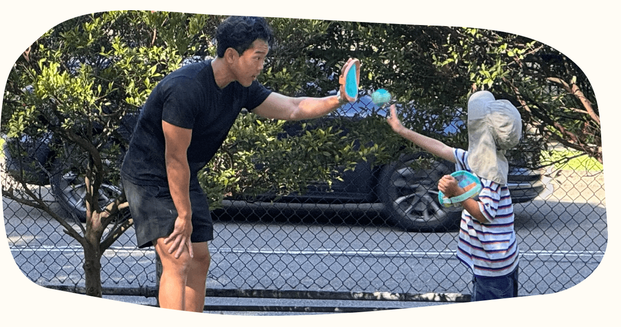 A child and clinician playing a catching game outdoors