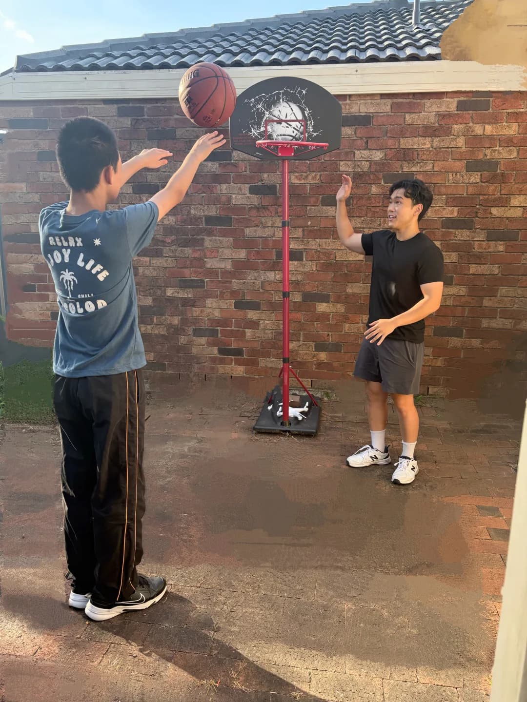 A child shooting a basketball at a backyard hoop