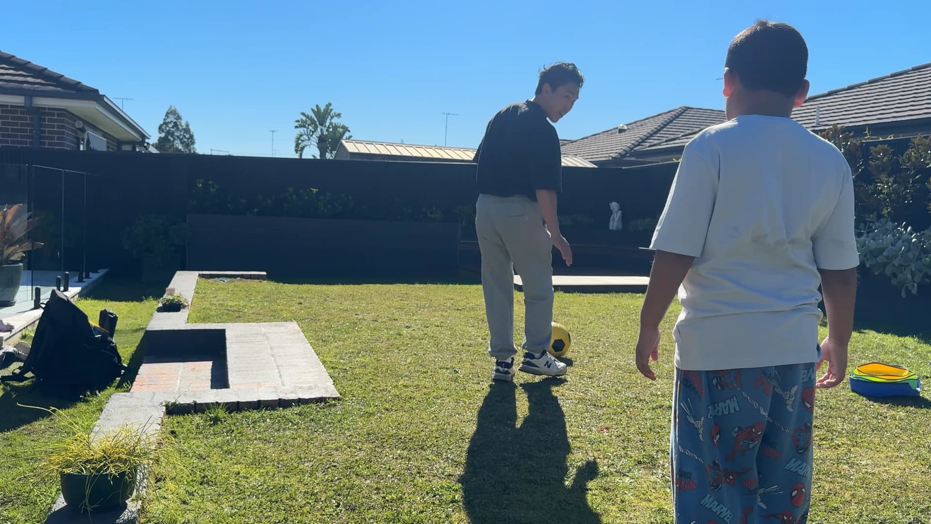 A therapist showing a child how to kick a ball