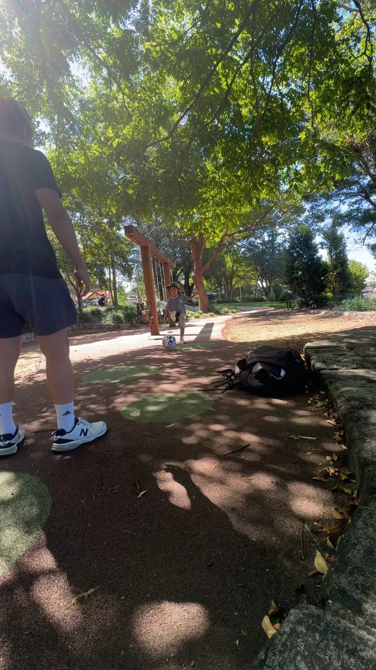 A child and therapist playing soccer in the park