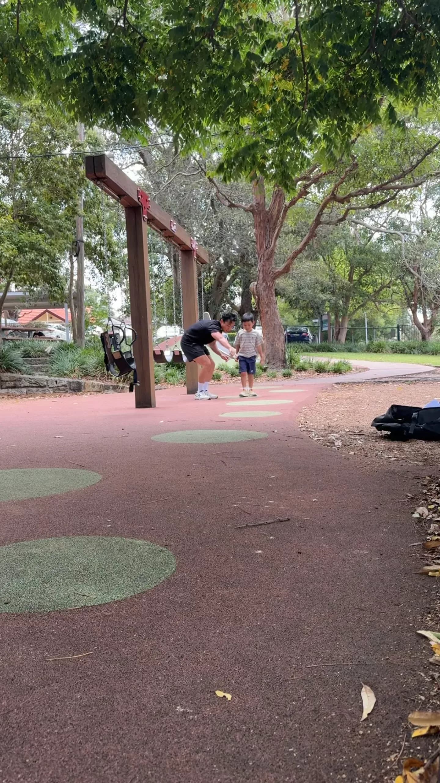 A child and clinician playing a jumping game on a park court